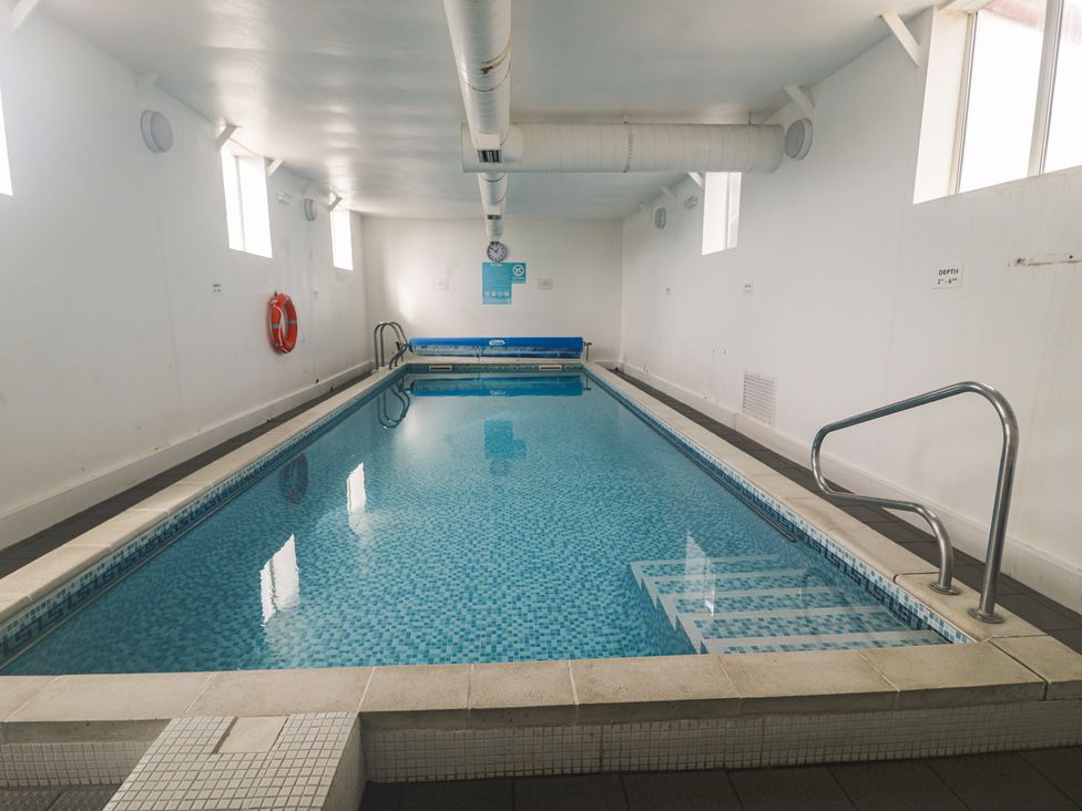 An indoor swimming pool with a lifebuoy and signage at Platinum Lodge (503) Talybont