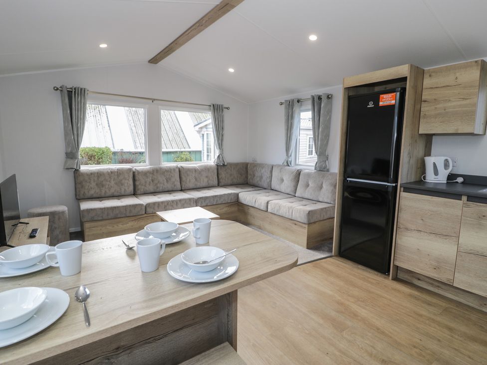 A living room with a sofa and dining table at Lido Silver Plus 111 Prestatyn