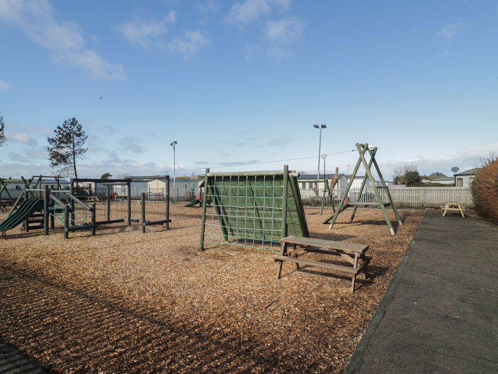A playground with swings and a climbing frame at Lido Silver Plus 111 Prestatyn