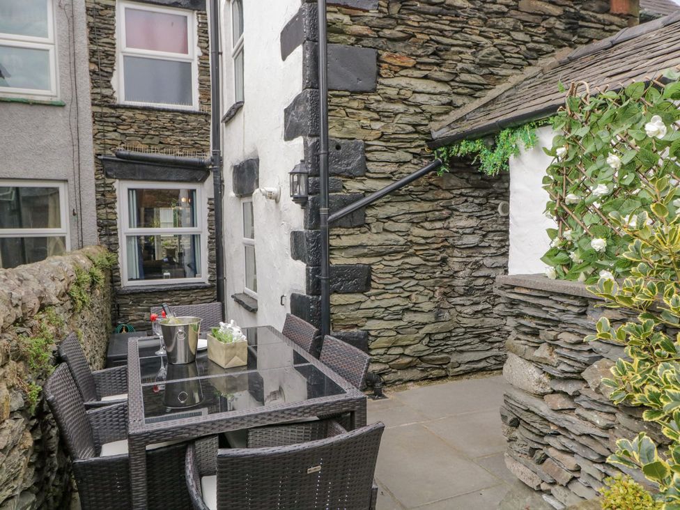 An outdoor seating area with a table and chairs at Nutkin Cottage in Windermere