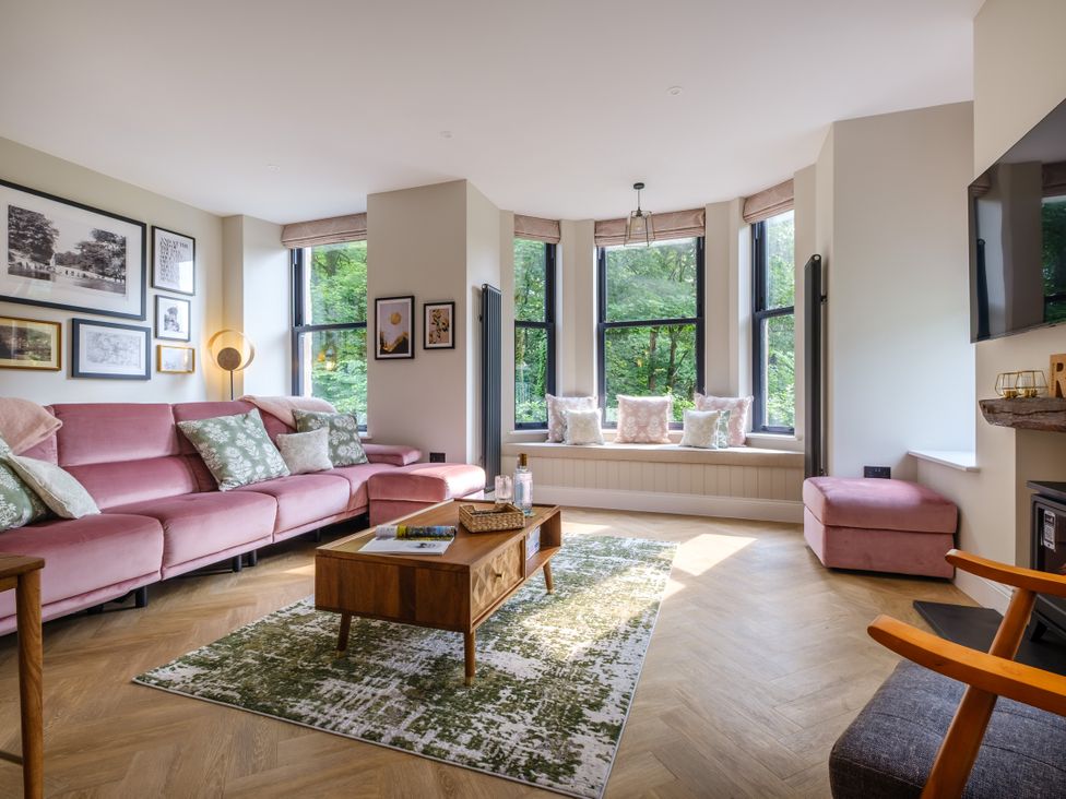A living room with a pink sofa and coffee table at Riverside in Ambleside