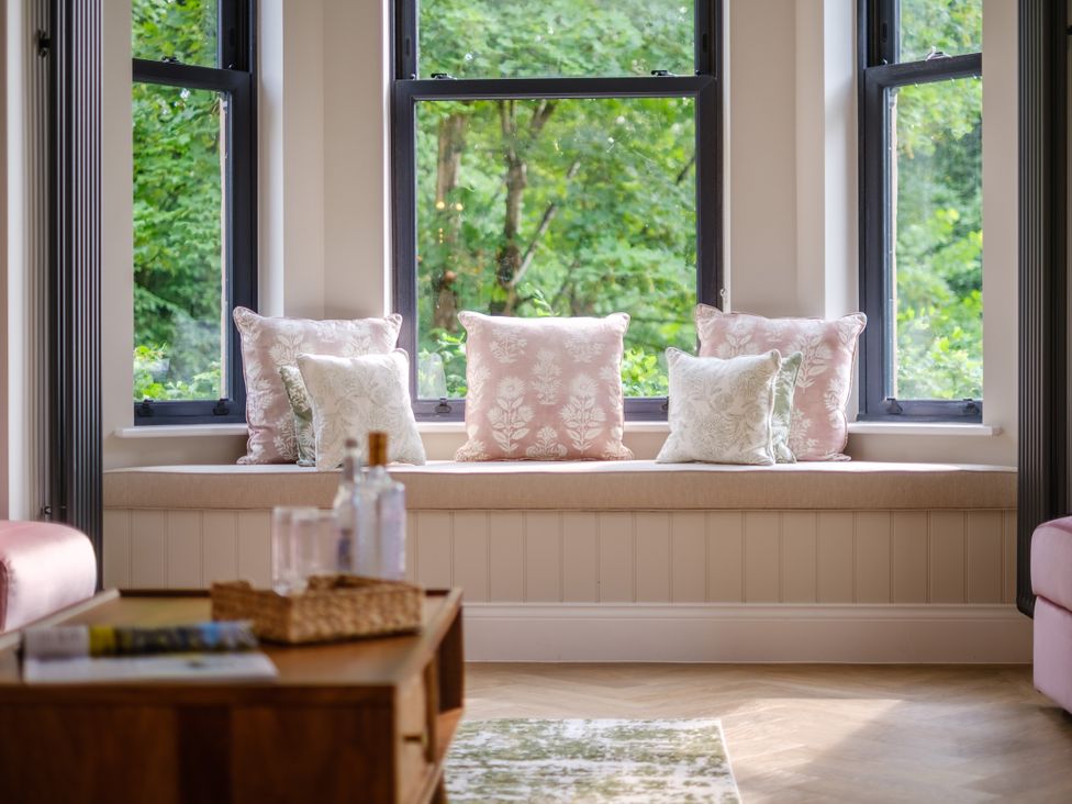A living room with cushions on a window seat at Riverside in Ambleside