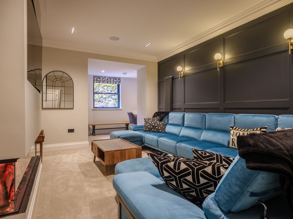 A living room with a blue sofa and coffee table at Riverside in Ambleside