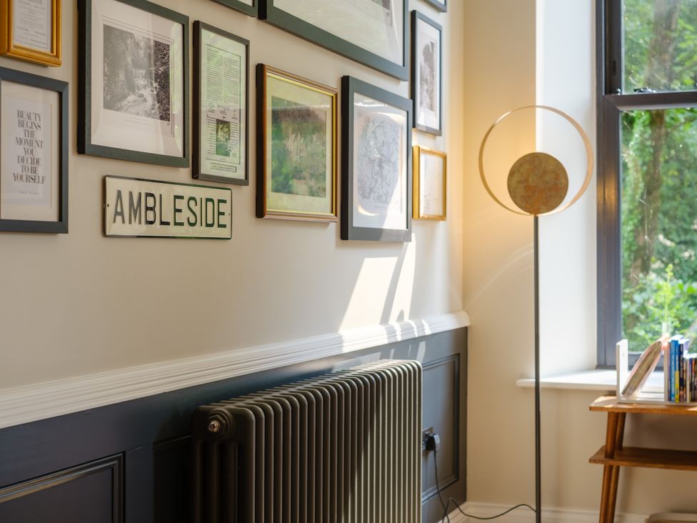 A sitting area with framed pictures and a lamp at Riverside in Ambleside