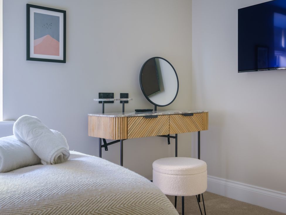 A bedroom with a console table and mirror at Riverside in Ambleside