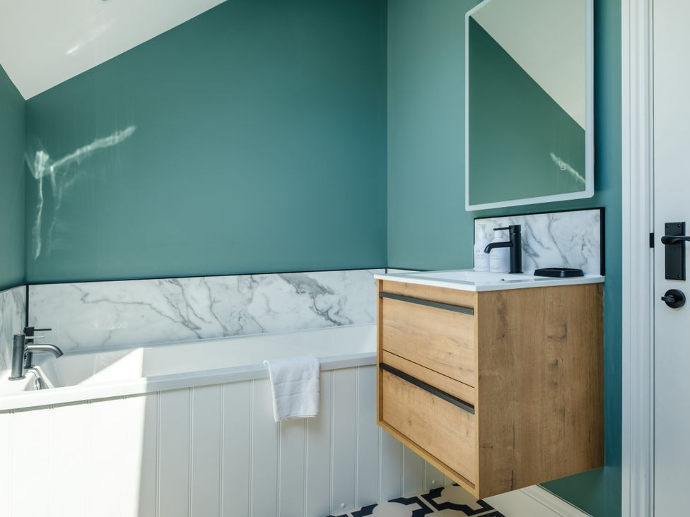 A bathroom with a bathtub and sink at Riverside in Ambleside