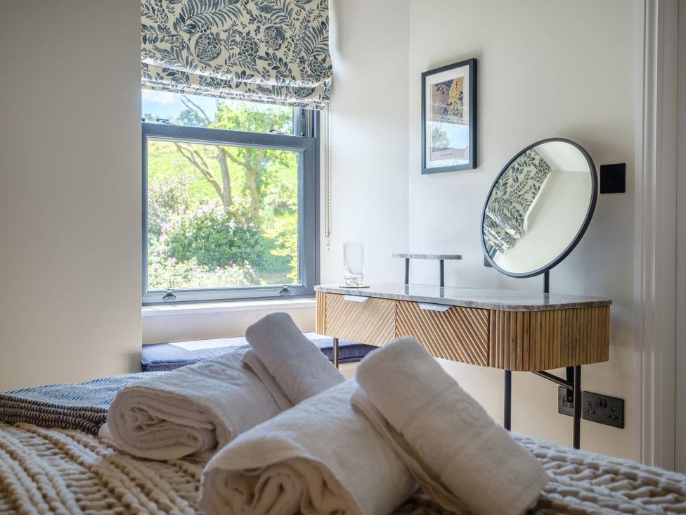 A bedroom with a bed and towels on it at Riverside in Ambleside