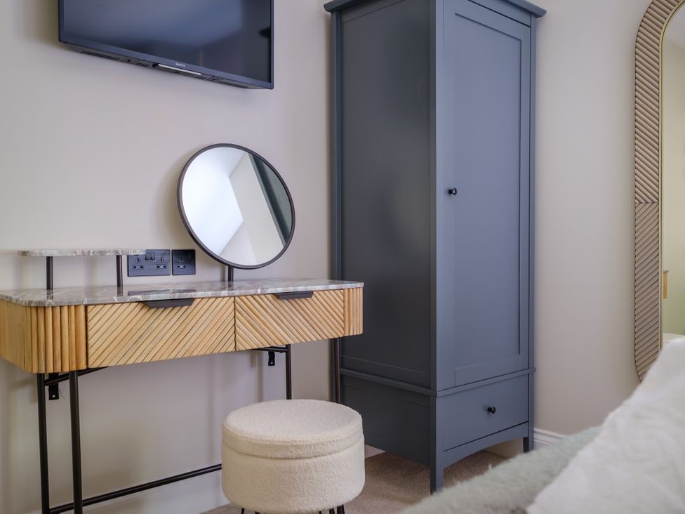 A bedroom with a vanity table and wardrobe at Riverside in Ambleside