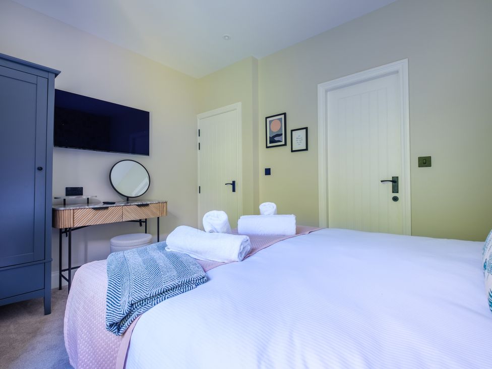 A bedroom with a bed and a wardrobe at Riverside in Ambleside