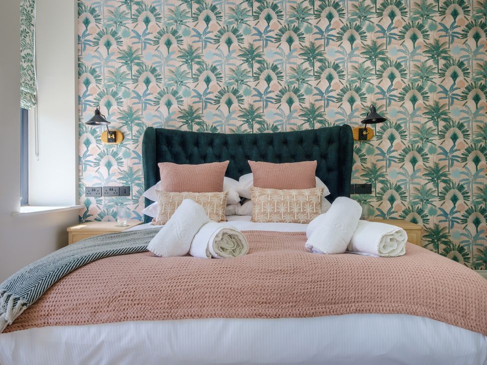 A bedroom with a bed and wallpaper at Riverside in Ambleside