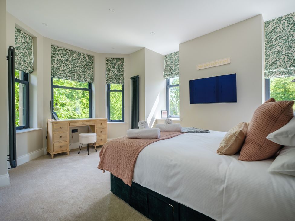 A bedroom with a bed, desk, and television at Riverside in Ambleside