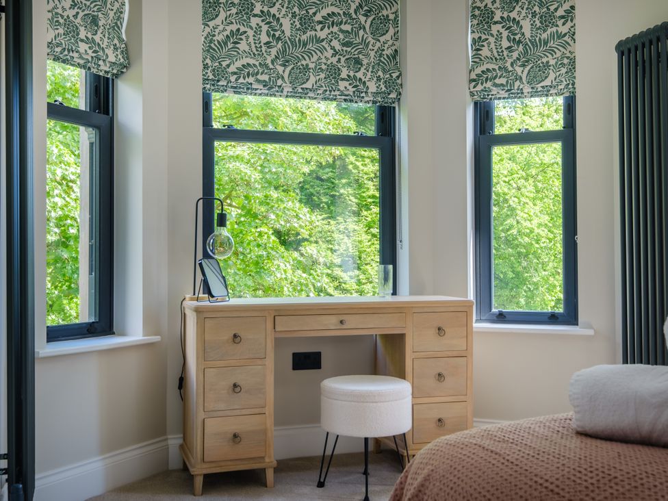 A bedroom with a desk and windows at Riverside in Ambleside