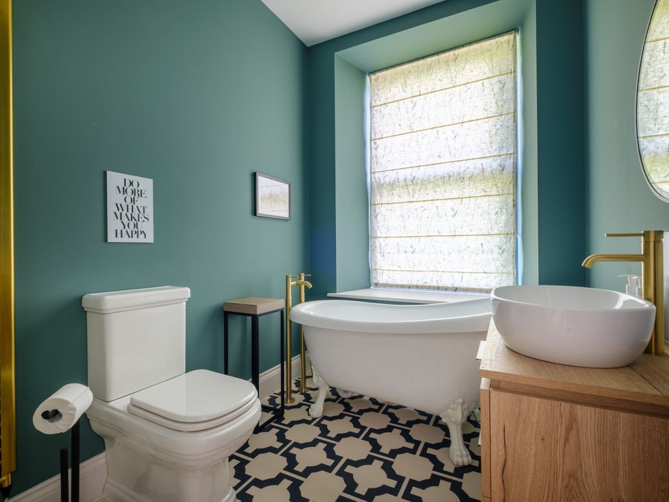 A bathroom with a bathtub and wash basin at Riverside in Ambleside