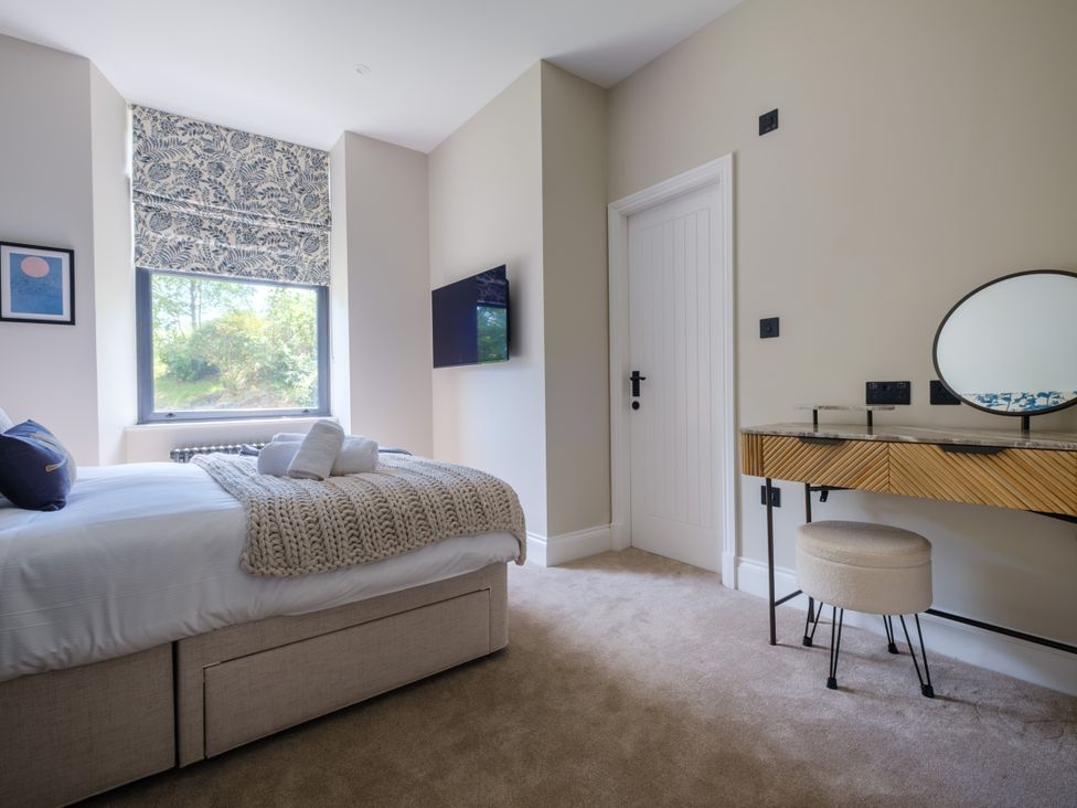 A bedroom with a bed and dresser at Riverside in Ambleside