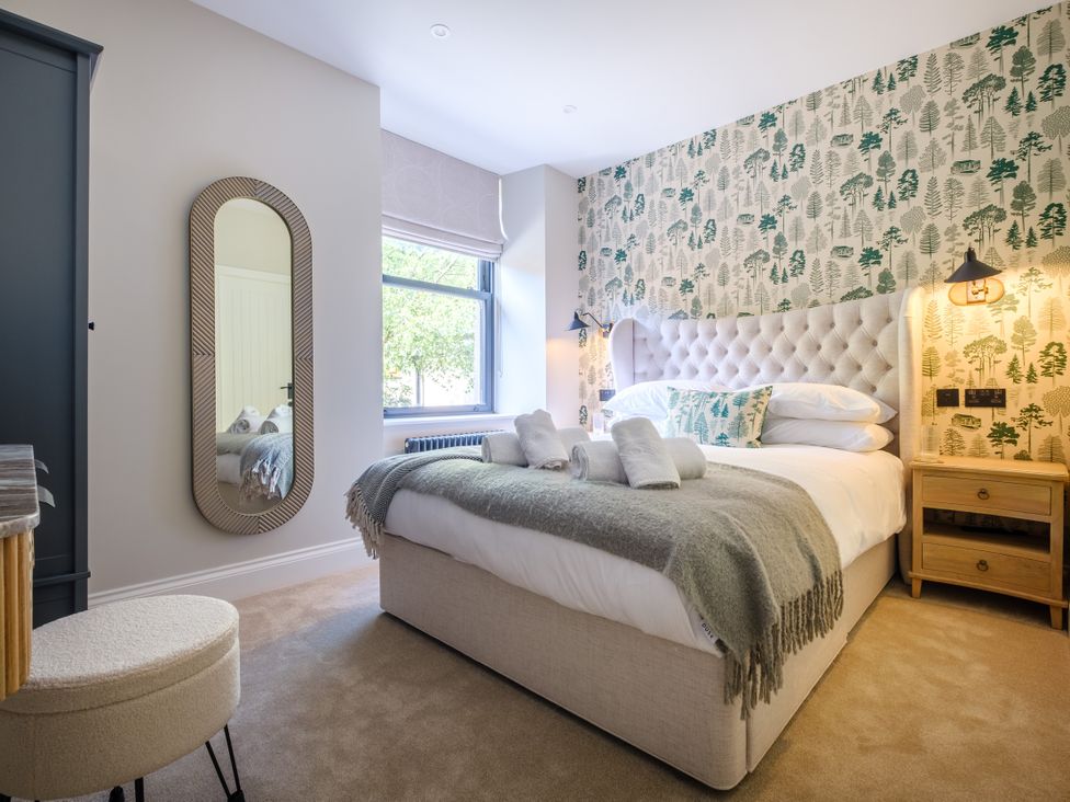 A bedroom with a bed and mirror at Riverside in Ambleside