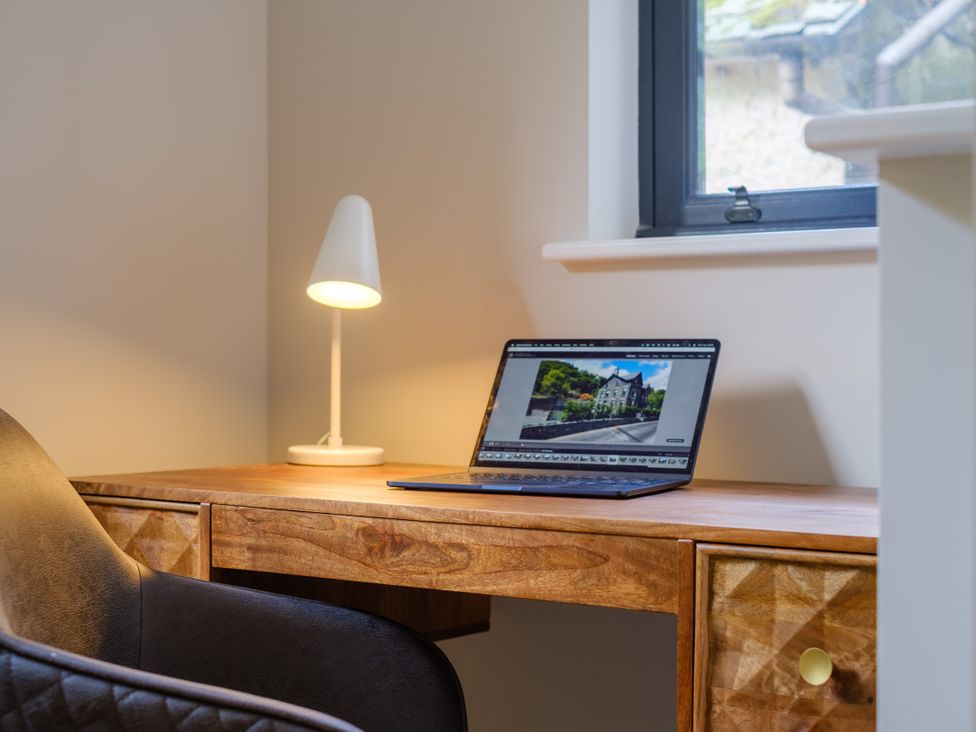 An office with a desk, lamp, and laptop at Riverside in Ambleside
