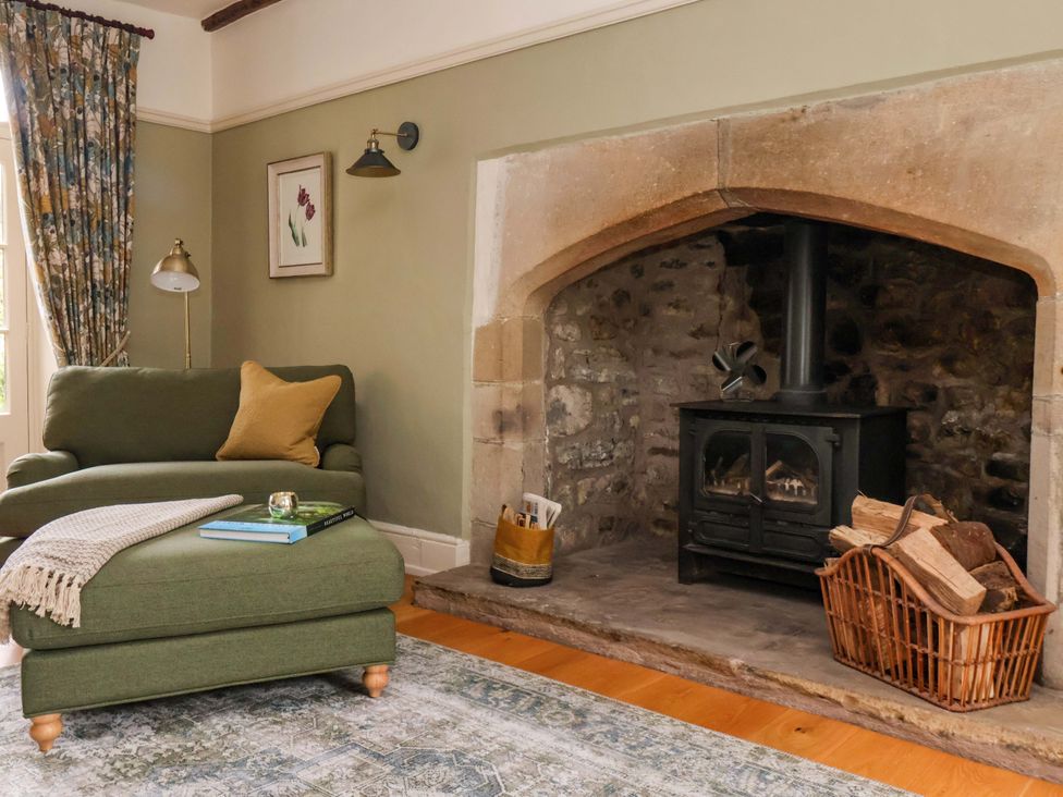 A living room with an armchair and fireplace at Ellis House in Skipton
