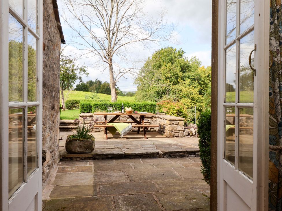 An outdoor area with a table and benches at Ellis House in Skipton