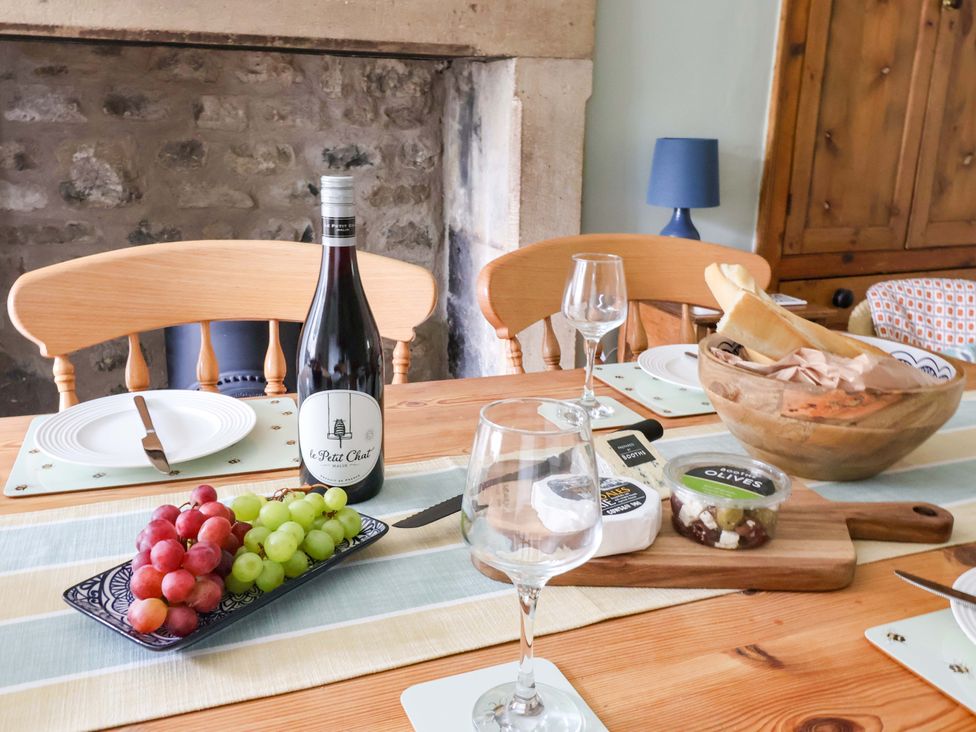 A dining room table with wine, grapes, and cheese at Ellis House in Skipton
