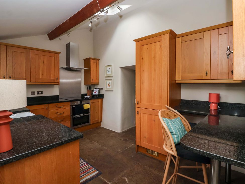 A kitchen with wooden cabinets and appliances at Ellis House in Skipton