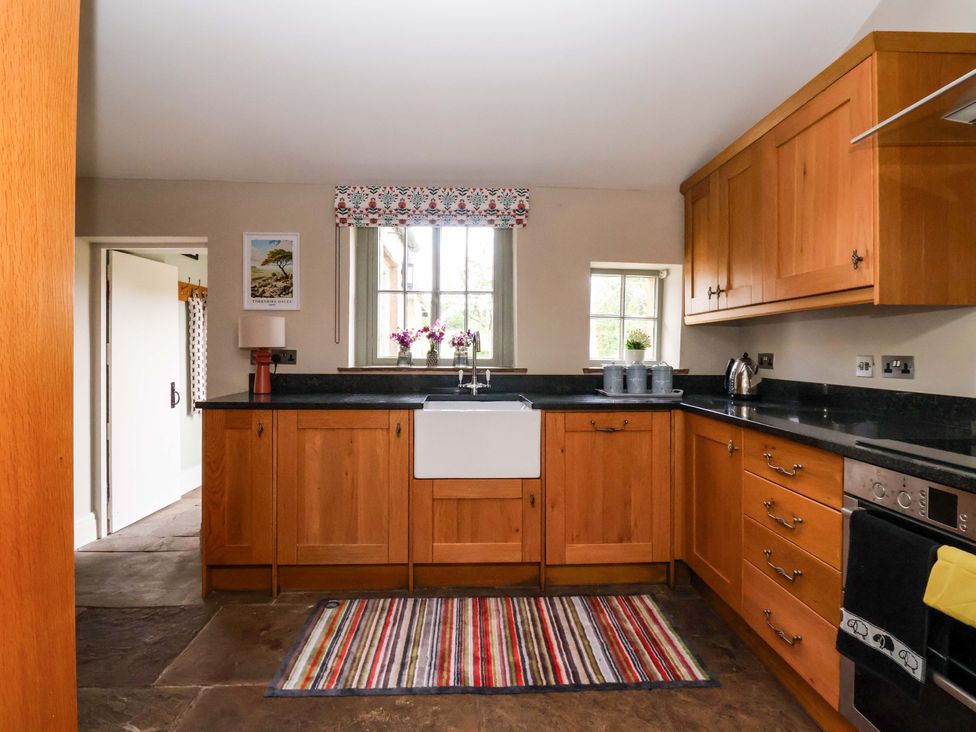 A kitchen with wooden cabinets and a sink at Ellis House in Skipton