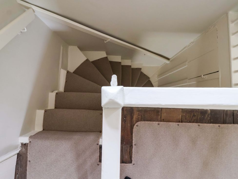 A staircase with carpeted steps and a white handrail at Ellis House in Skipton