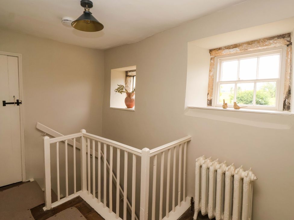 A hallway with a staircase and windows at Ellis House Skipton