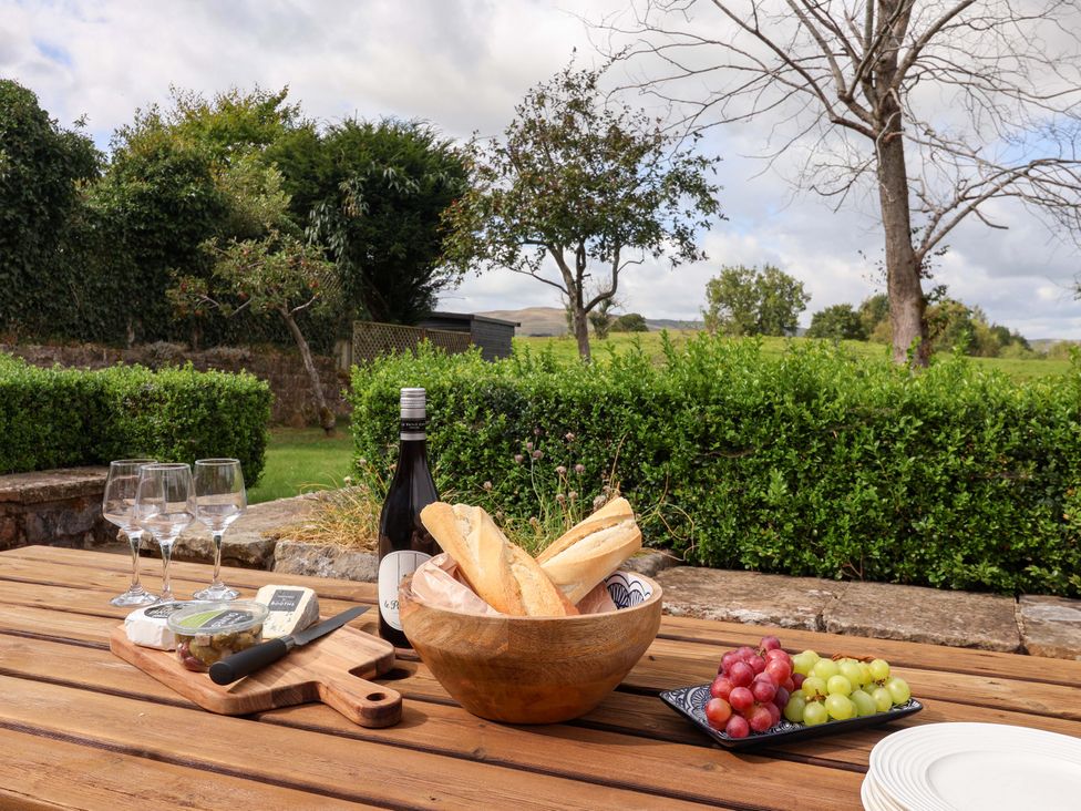A table with bread, cheese, grapes, and wine glasses at Ellis House in Skipton