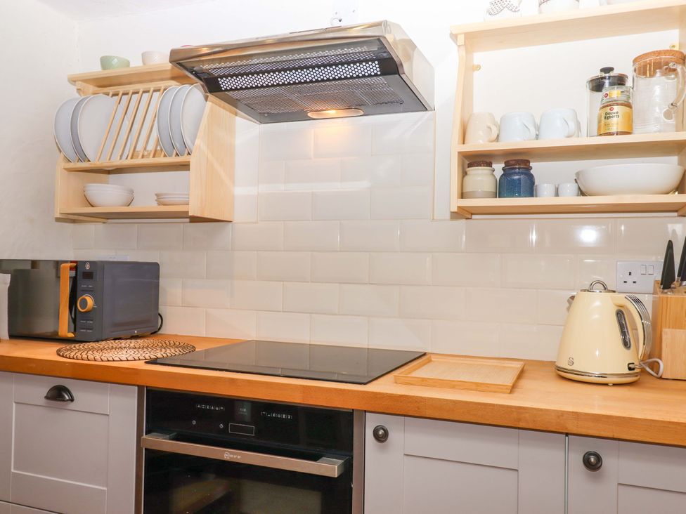 A kitchen with a microwave, hob, and kettle at 1 Myrtle Cottages in Stokeinteignhead