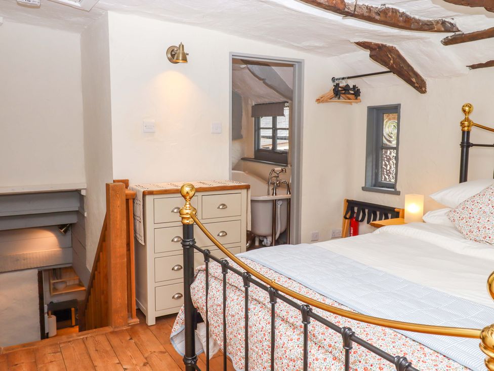 A bedroom with a bed and nightstand at 1 Myrtle Cottages Stokeinteignhead