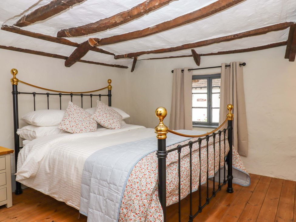 A bedroom with a bed and pillows at 1 Myrtle Cottages in Stokeinteignhead
