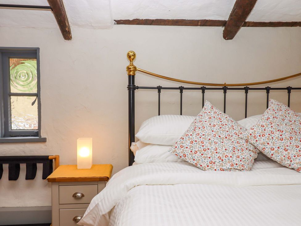 A bedroom with a bed and lamp at 1 Myrtle Cottages Stokeinteignhead