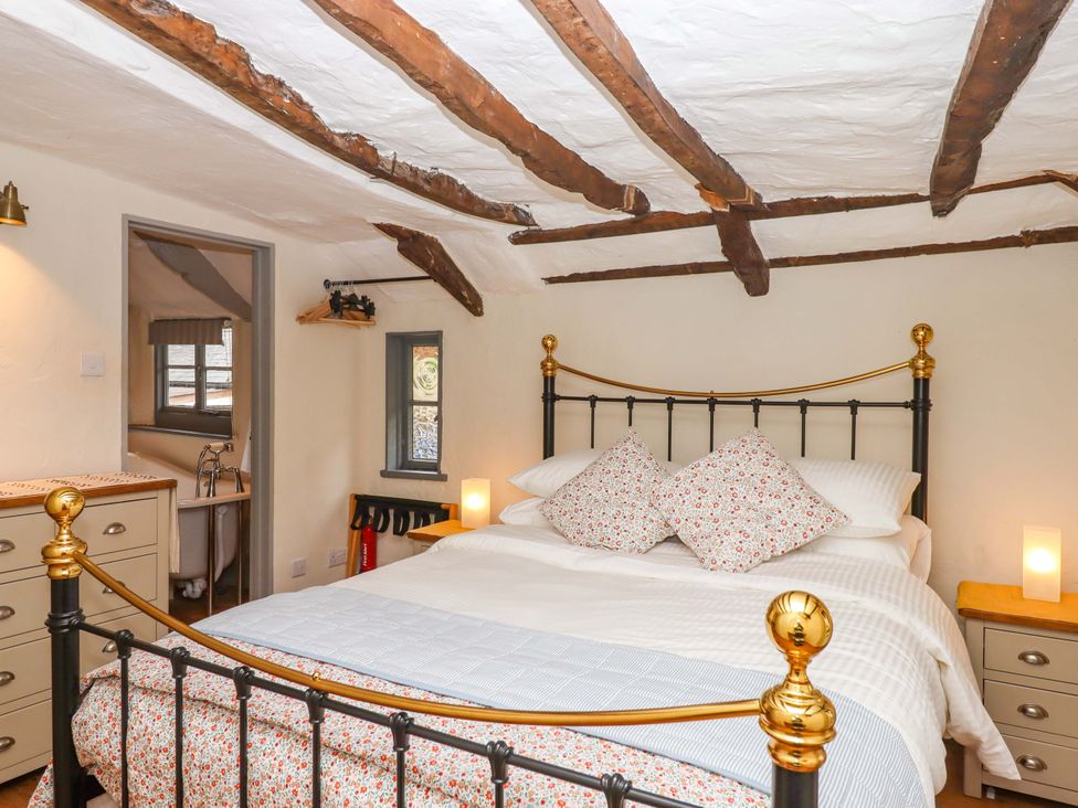 A bedroom with a bed and a window at 1 Myrtle Cottages Stokeinteignhead