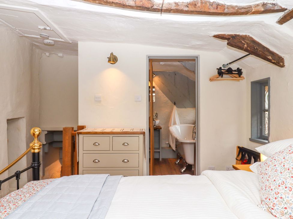 A bedroom with a bed and a bathroom view at 1 Myrtle Cottages Stokeinteignhead