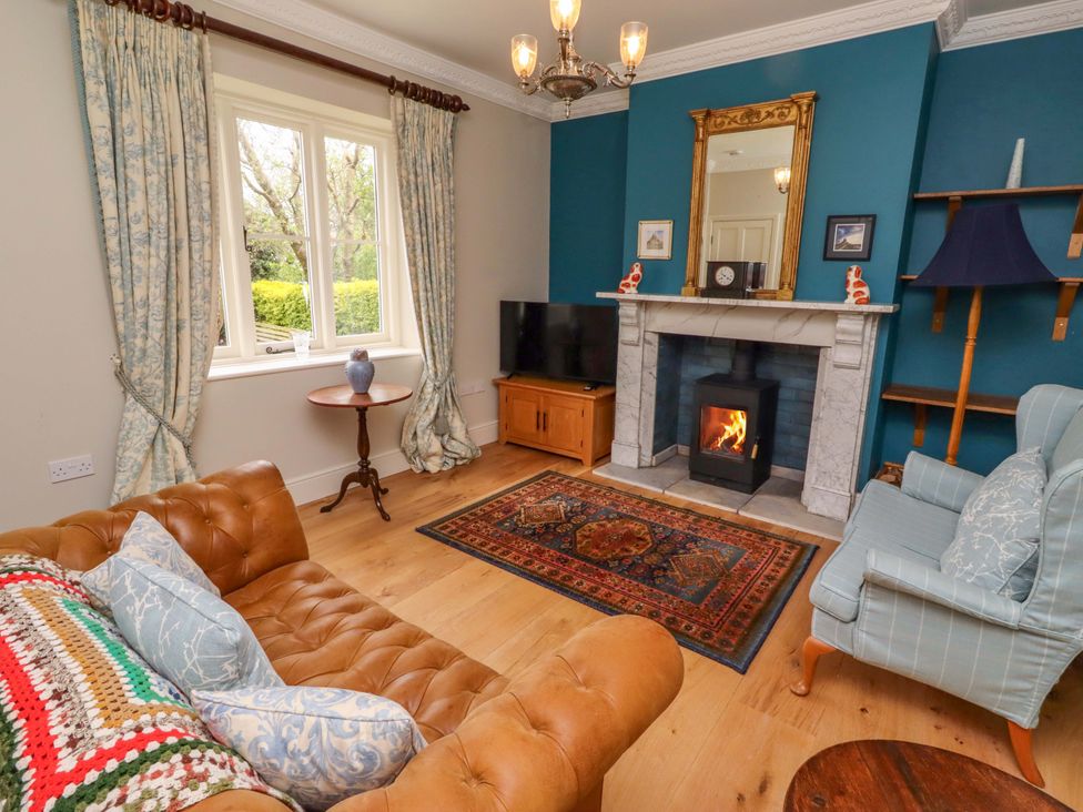 A living room with a fireplace and sofa at 9 Longhirst Village in Morpeth