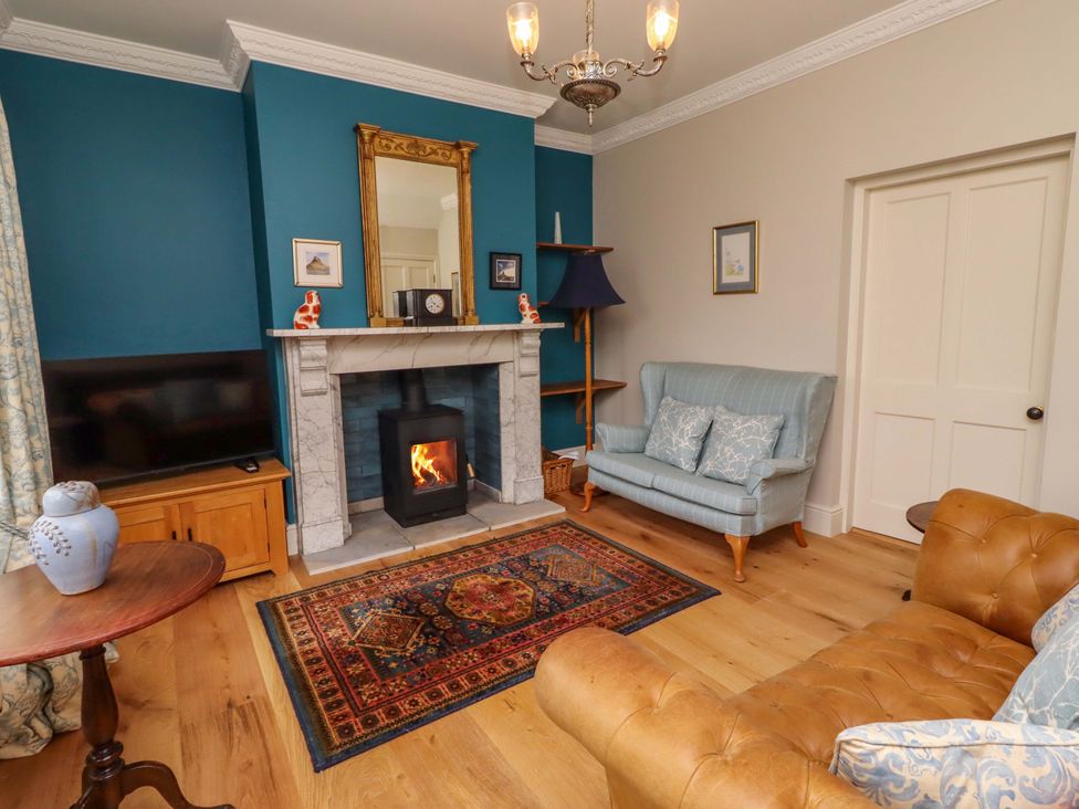 A living room with a fireplace and television at 9 Longhirst Village in Morpeth