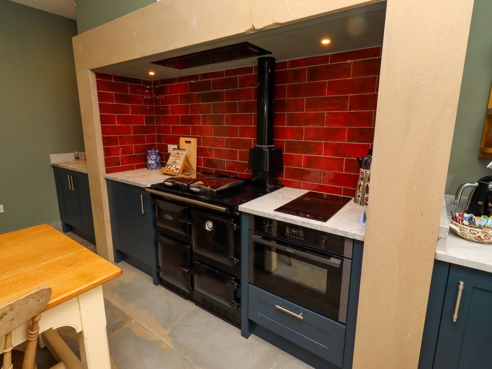 A kitchen with appliances and cabinets at 9 Longhirst Village Morpeth