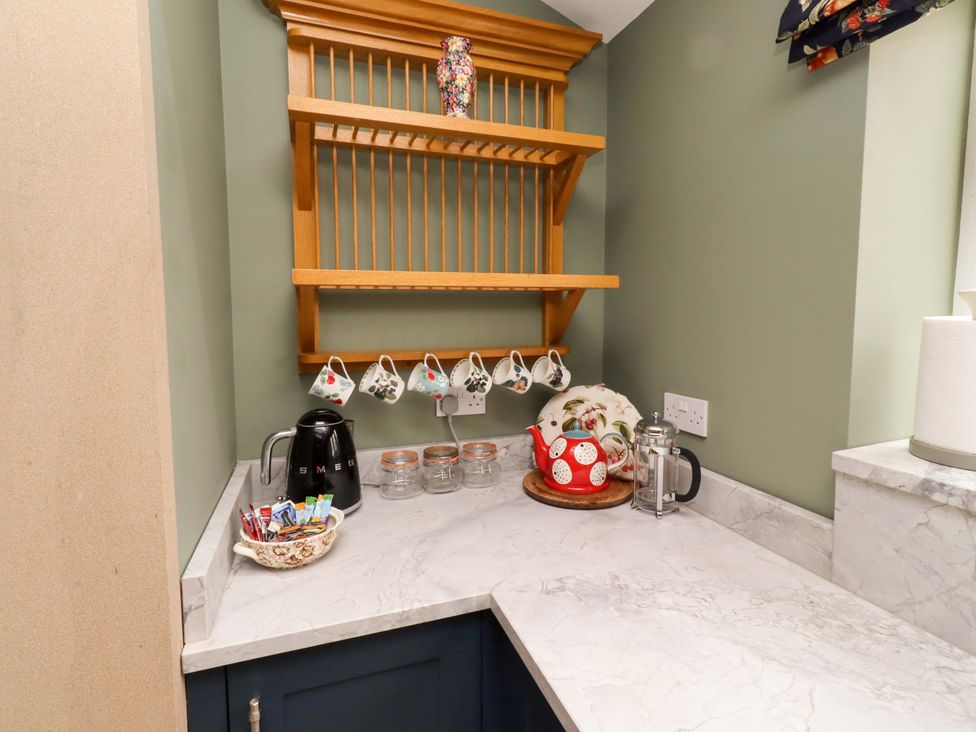 A kitchen with a kettle and mugs on a shelf at 9 Longhirst Village in Morpeth