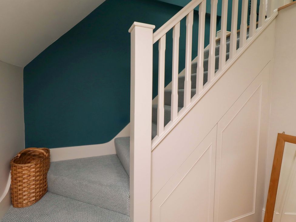 A staircase with a handrail and a basket at 9 Longhirst Village, Morpeth