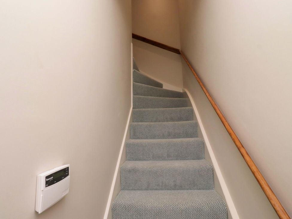 A staircase with carpet and a handrail at 9 Longhirst Village Morpeth