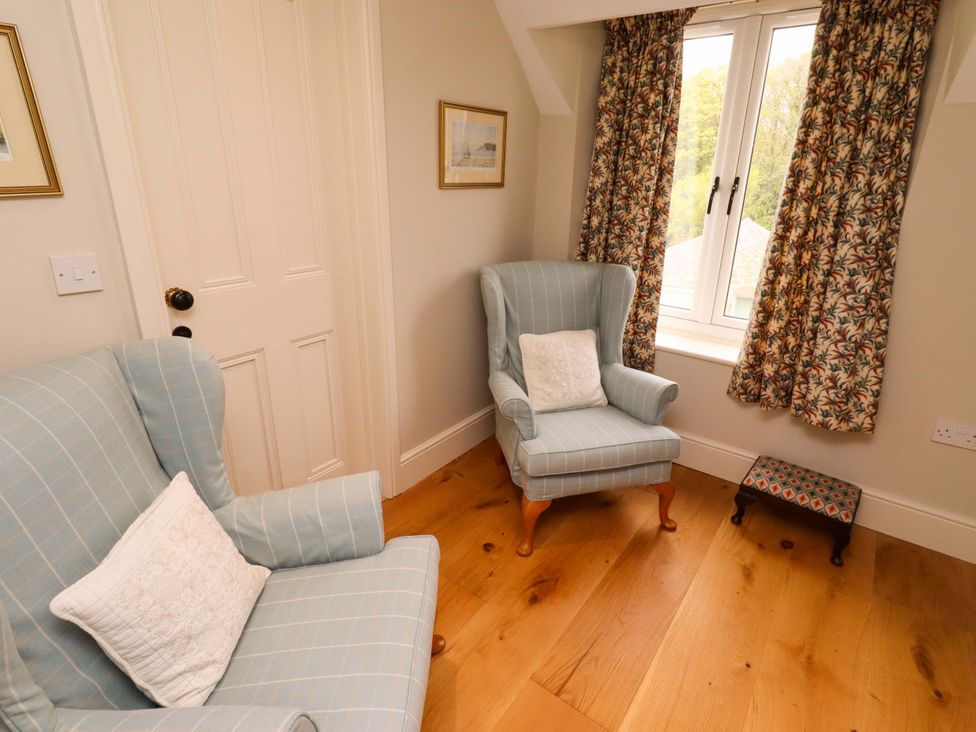 A sitting room with armchairs and a small footstool at 9 Longhirst Village Morpeth