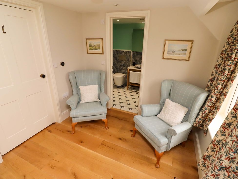 A sitting room with two chairs and a table at 9 Longhirst Village in Morpeth