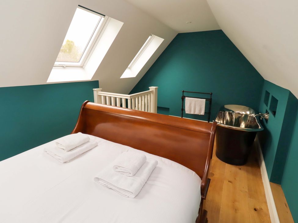 A bedroom with a bed and bathtub at 9 Longhirst Village in Morpeth