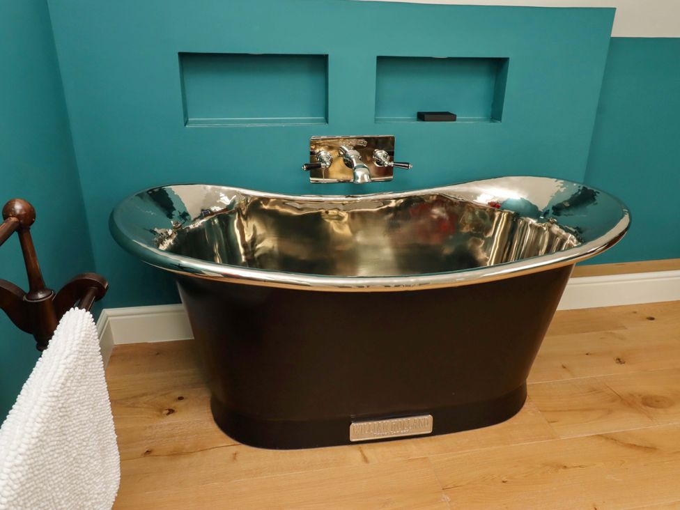 A bathroom with a bathtub and faucet at 9 Longhirst Village in Morpeth