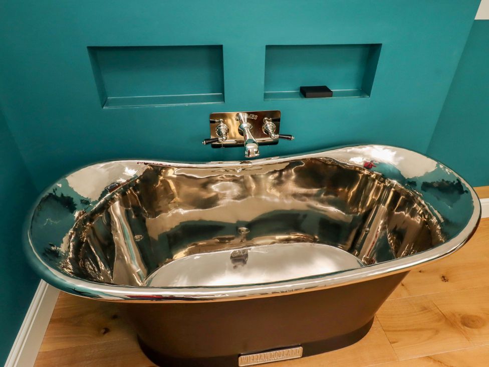 A bathtub with faucet in a bathroom at 9 Longhirst Village Morpeth