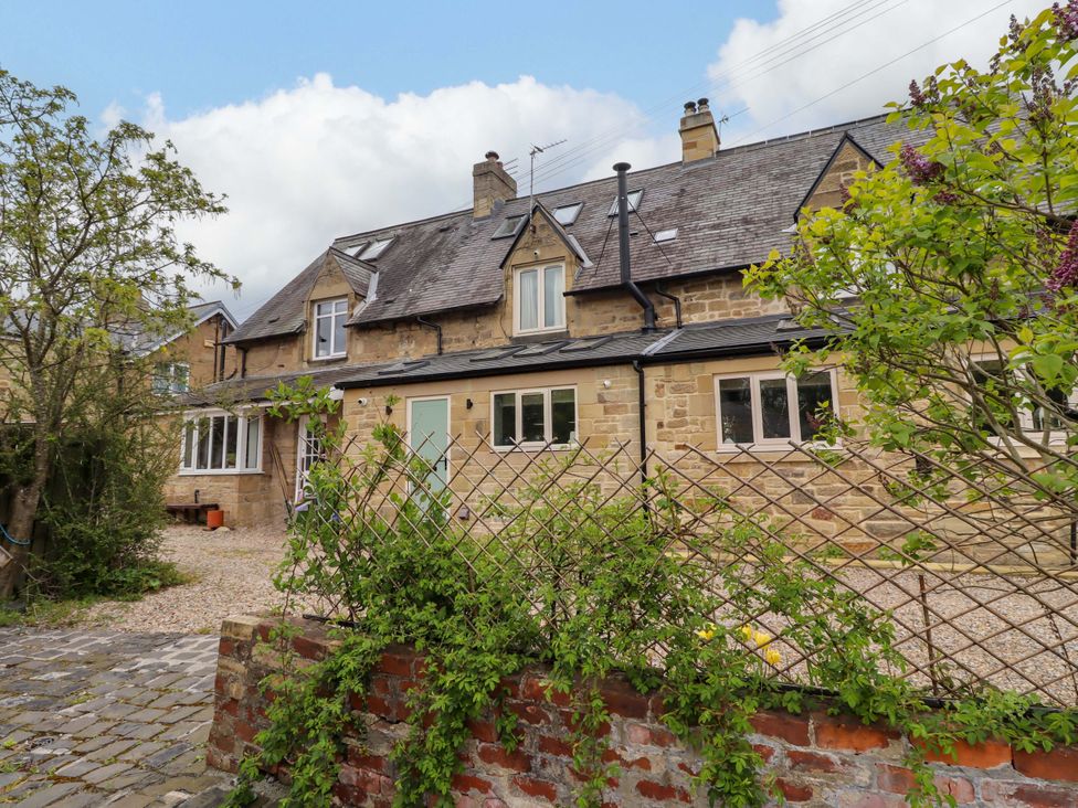 A house with gravel driveway and plants at 9 Longhirst Village in Morpeth