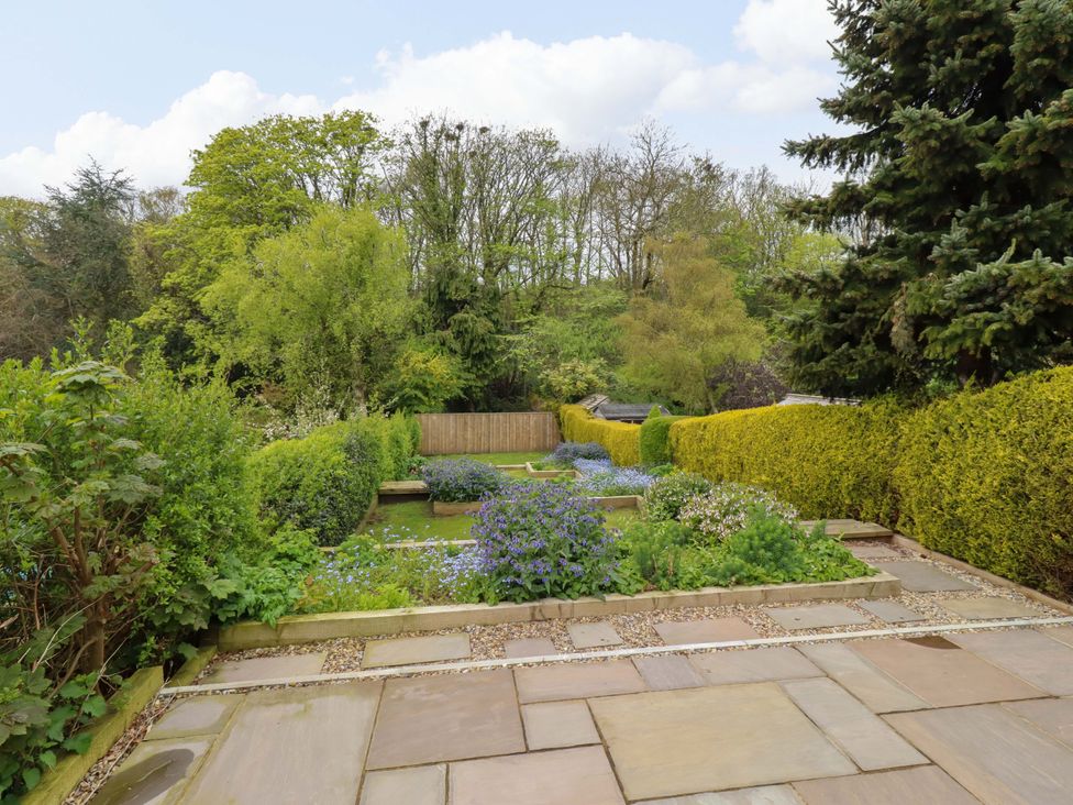A garden with grass and flowers at 9 Longhirst Village, Morpeth