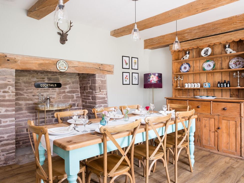 A dining room with a large table and wooden shelves at Henhouse Farm in Bodenham