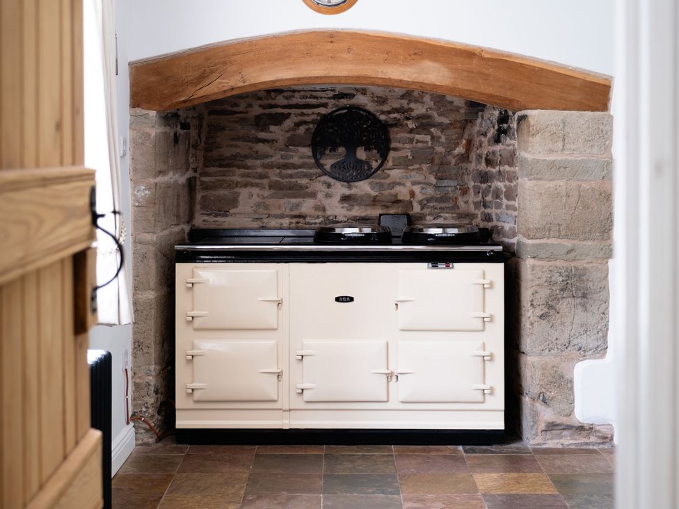 A kitchen with an oven and brick wall at Henhouse Farm in Bodenham
