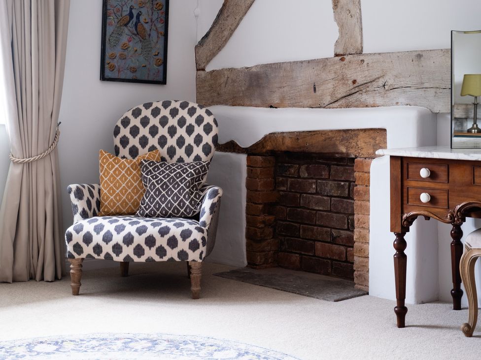 A living room with an armchair and fireplace at Henhouse Farm in Bodenham